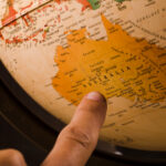 finger pointing to australia on map