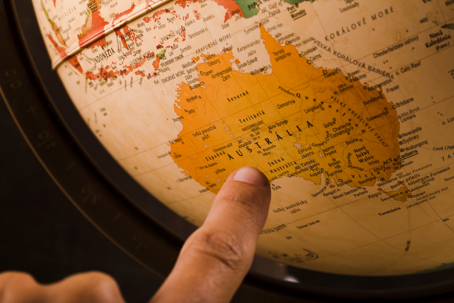 finger pointing to australia on map